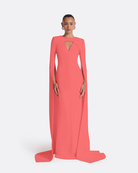 Coral evening gown with long sleeves and a slit on a white background