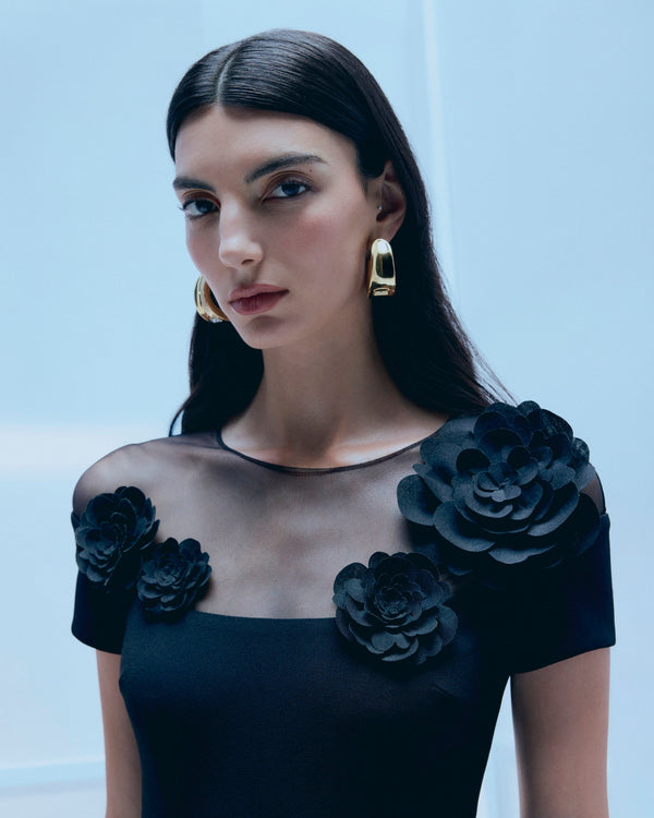 Woman wearing a black dress with floral details embellishment
